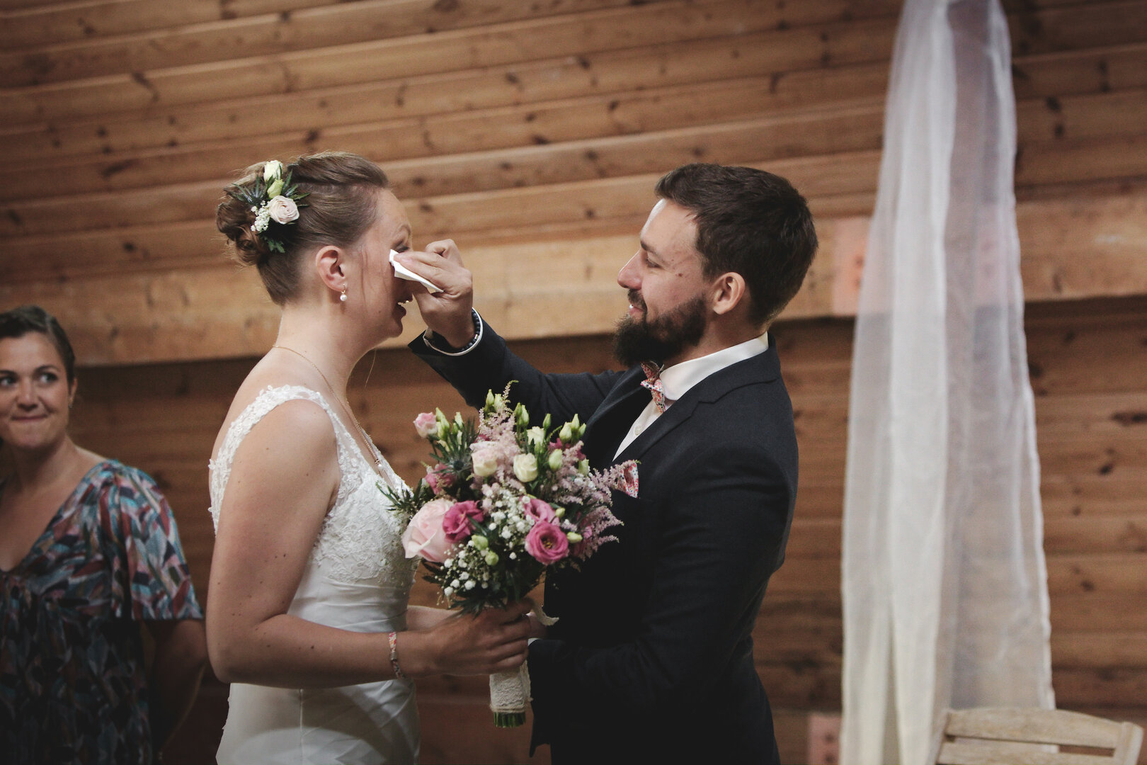 Le Marié essuie une larme de bonheur sur la joue de la mariée